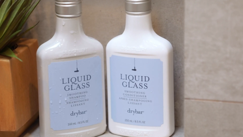 Two Bottles of Drybar Liquid Glass Smoothing Shampoo and Conditioner Placed Together on A Bathroom Shelf